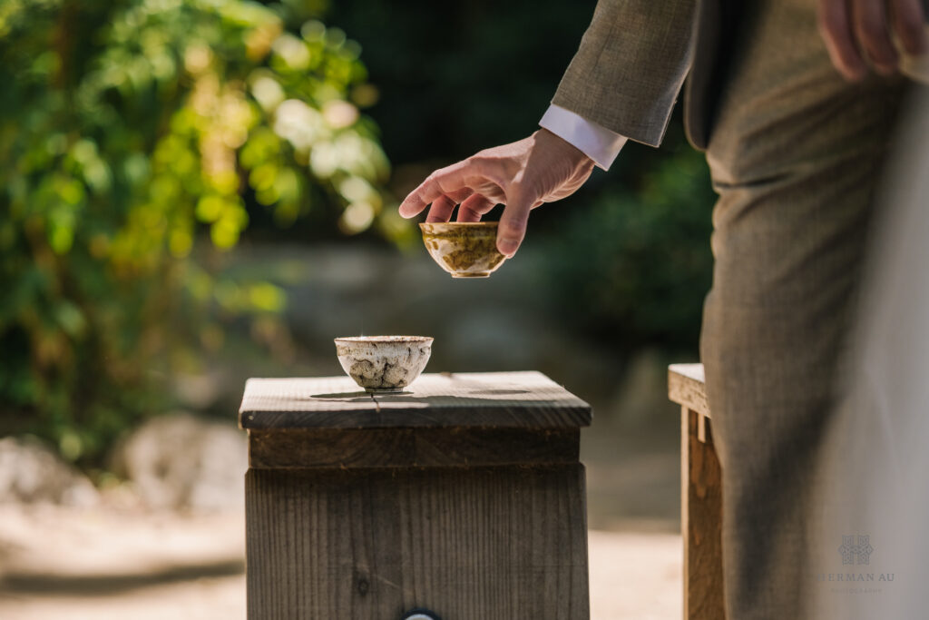 the very moment an ornate tea cup is picked up to be served at a tea ceremony